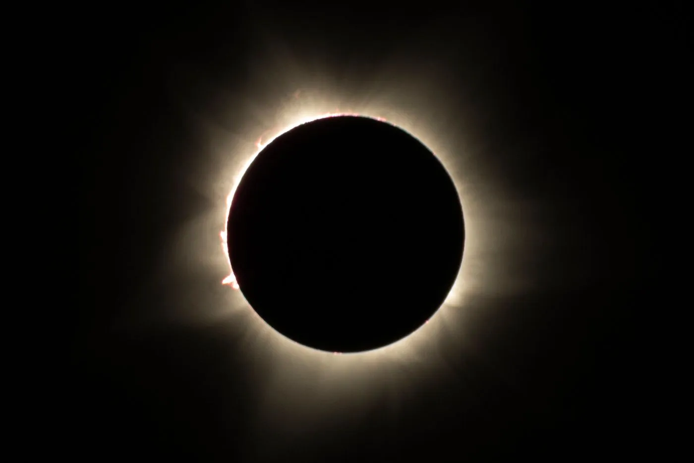 The sun's corona glowing around the moon during a total solar eclipse.